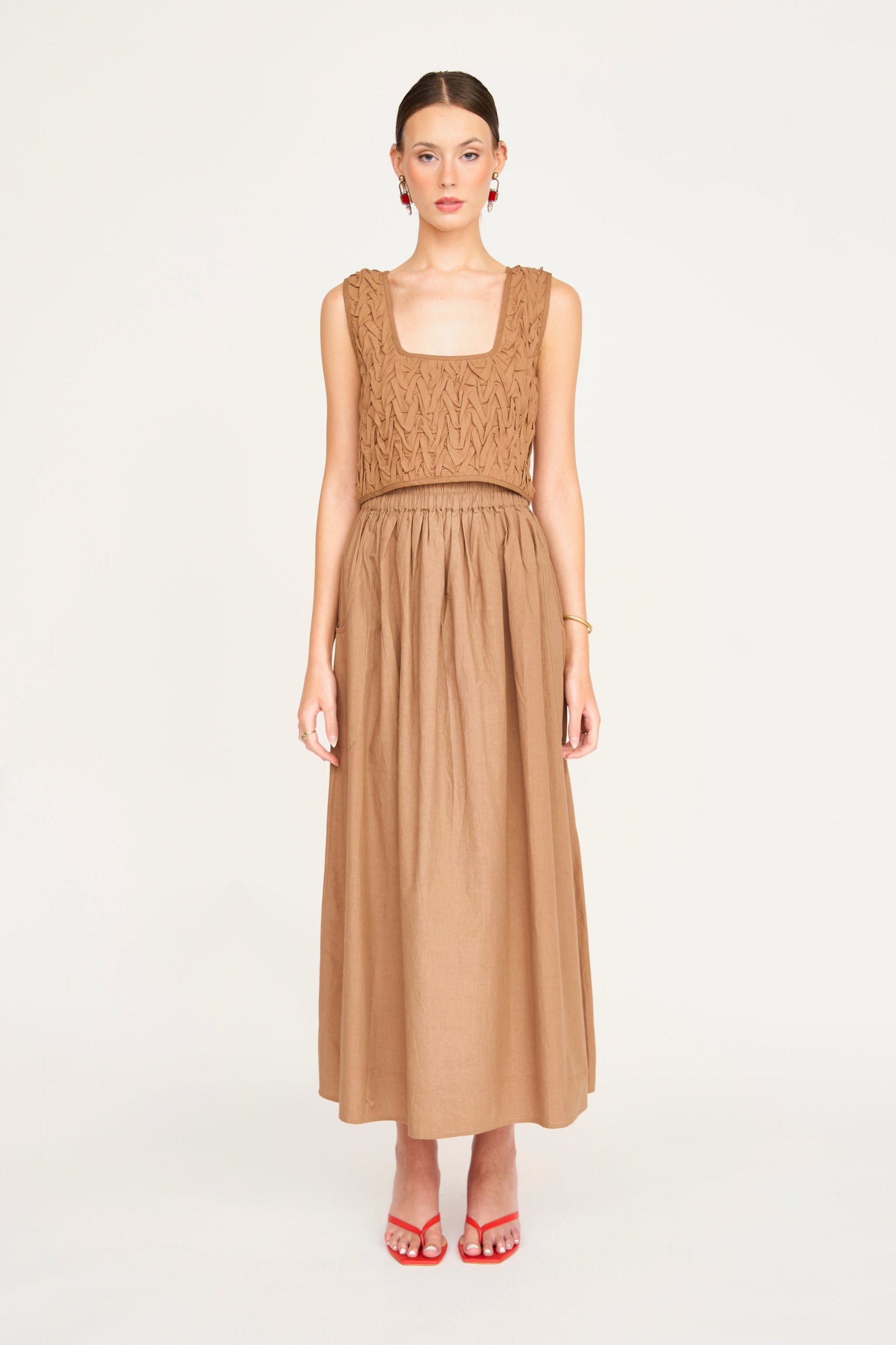 Tan cotton smocked top with textured bodice, ideal for casual wear, shown against a plain white background.
