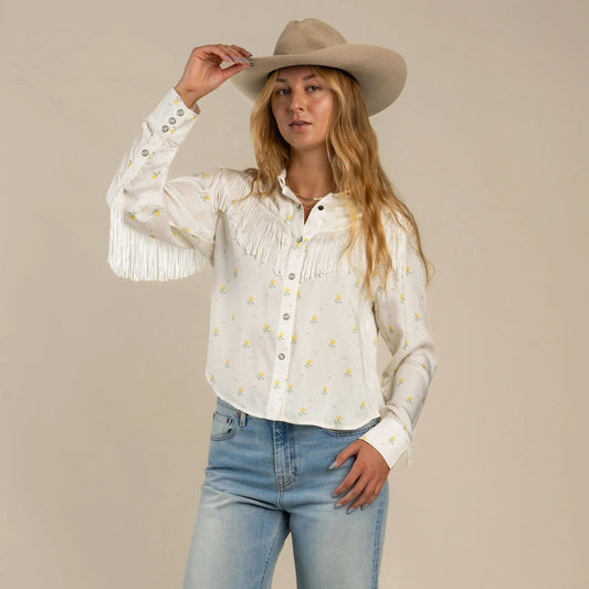 Woman wearing a white blouse with fringe details 