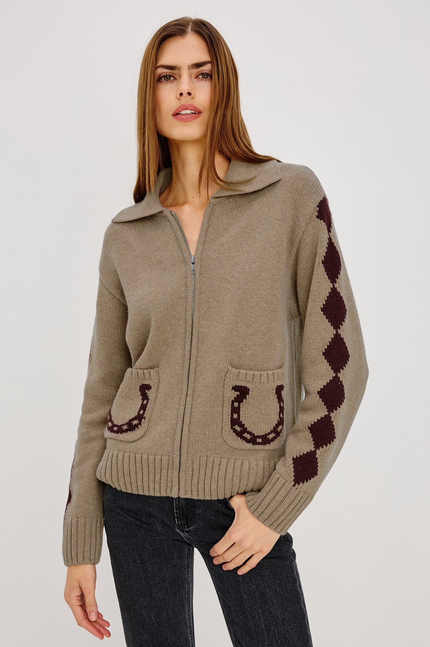 Woman wearing a beige sweater with horse shoe designs