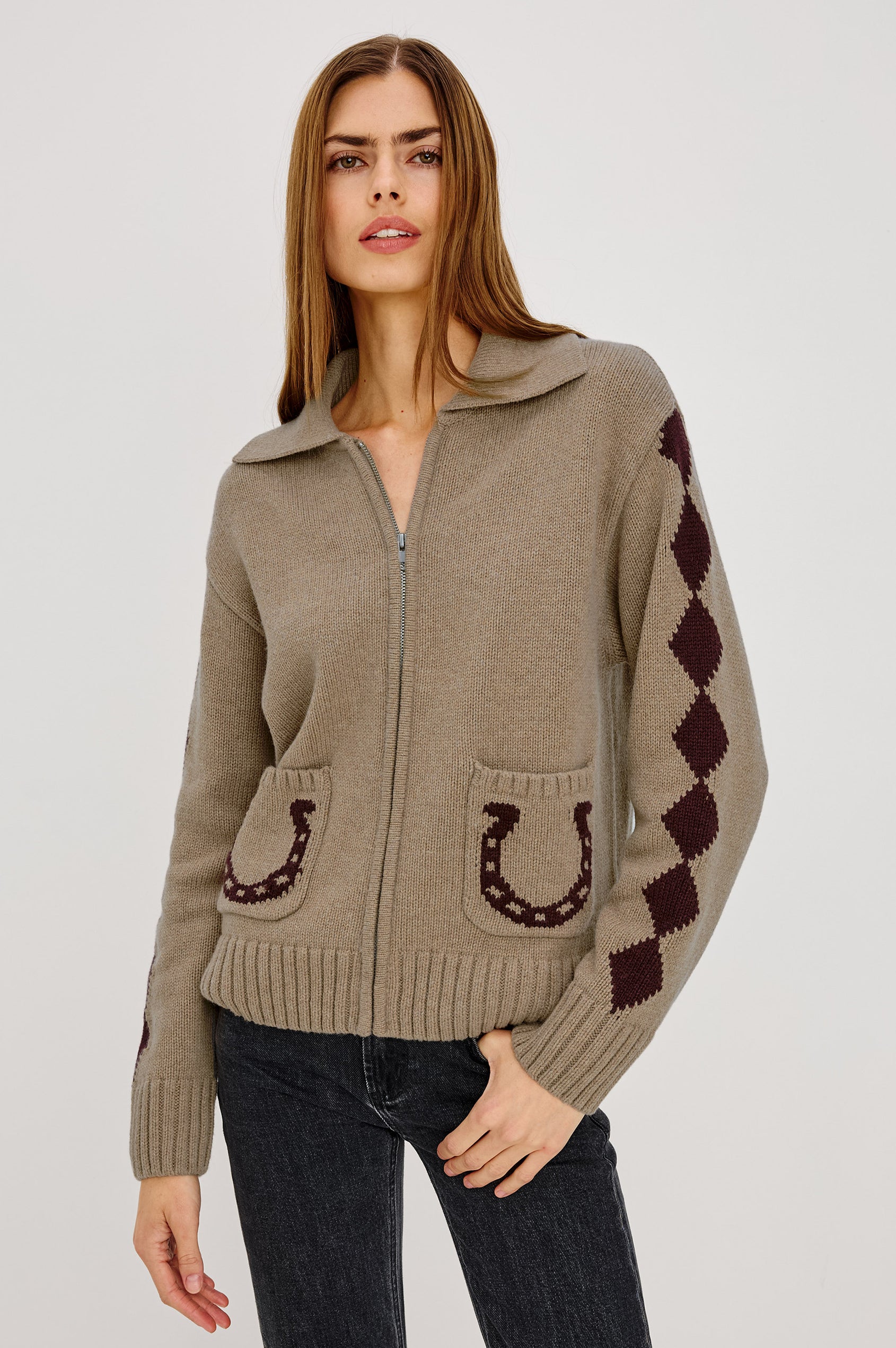 Woman wearing a beige sweater with horse shoe designs