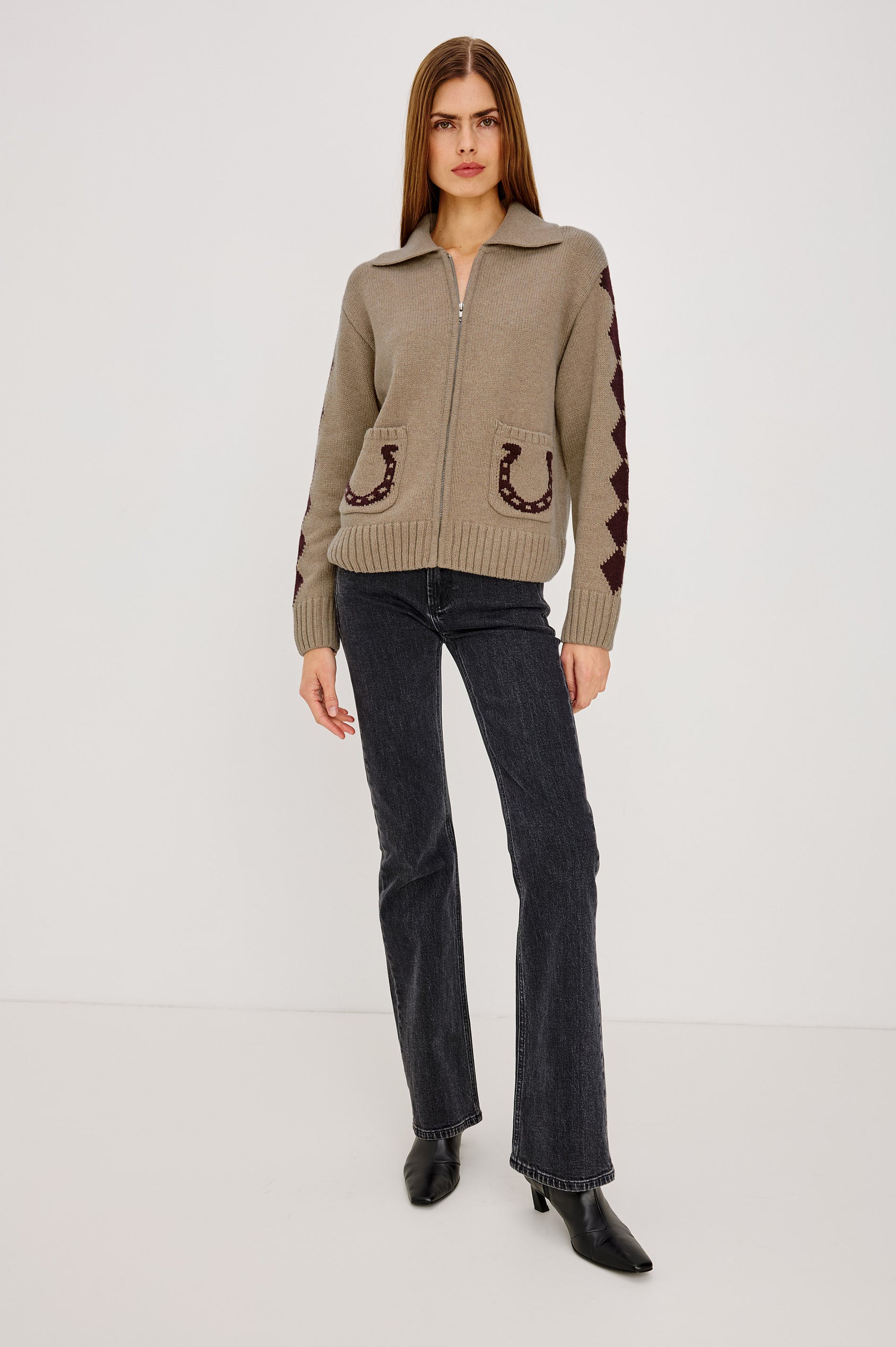 Woman wearing a beige sweater with horse shoe designs