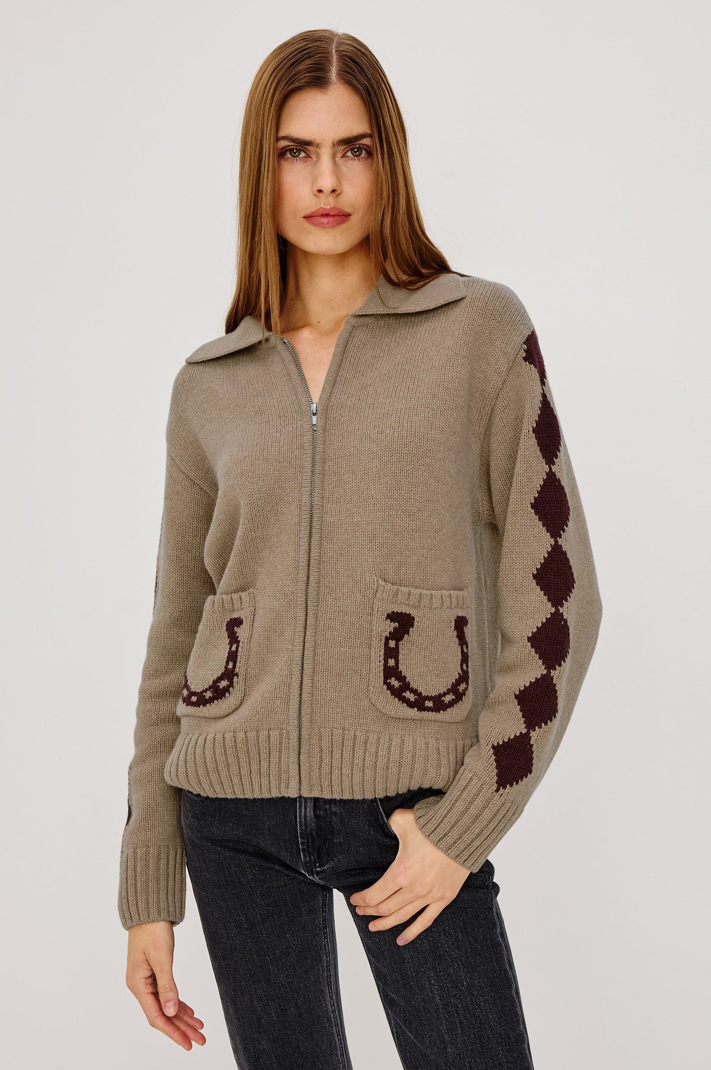 Woman wearing a beige sweater with horse shoe designs
