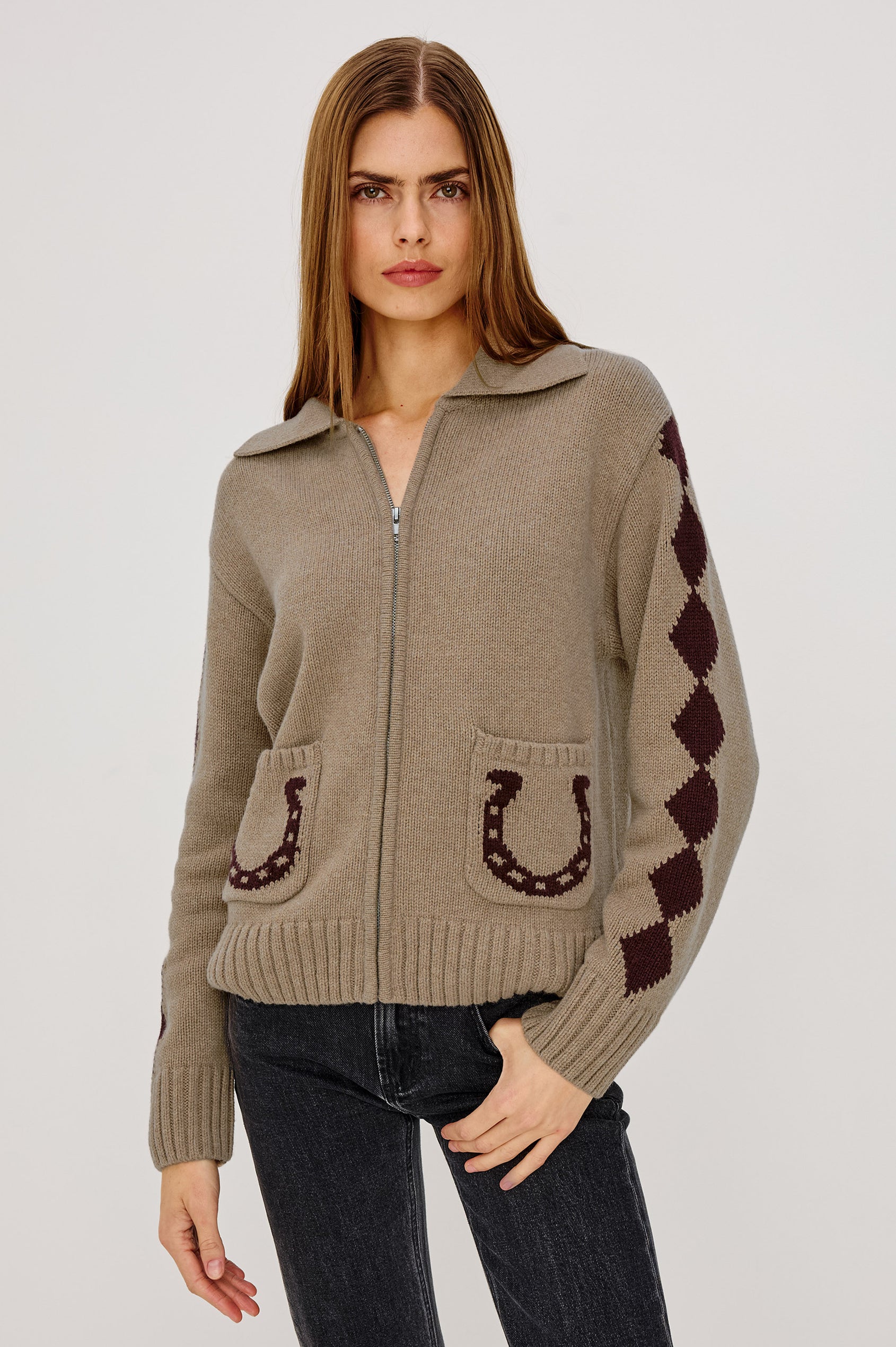 Woman wearing a beige sweater with horse shoe designs