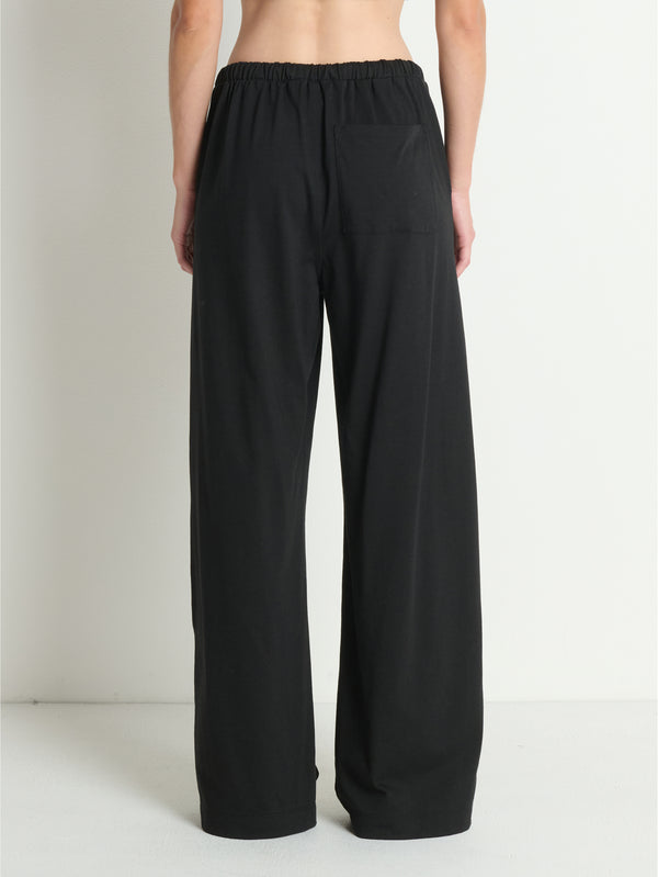 Back view of black cotton pants, shown on a person against a white background. Suitable for everyday casual wear.