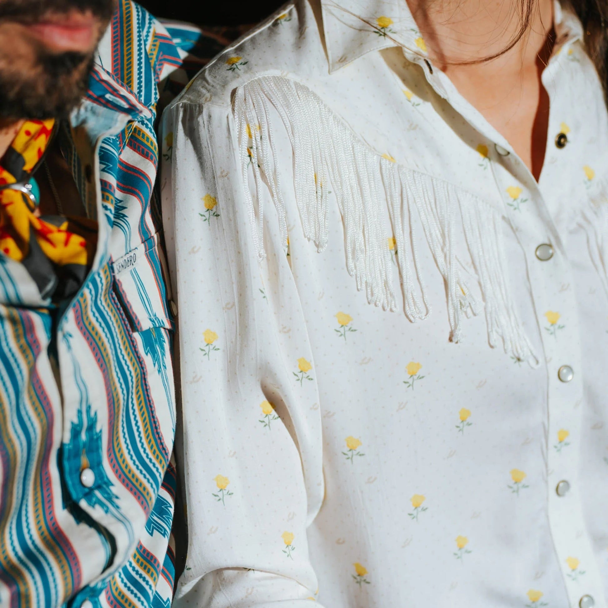 Woman wearing a white blouse with fringe details 