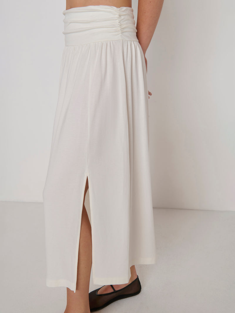 A woman modeling a cream-colored midi skirt