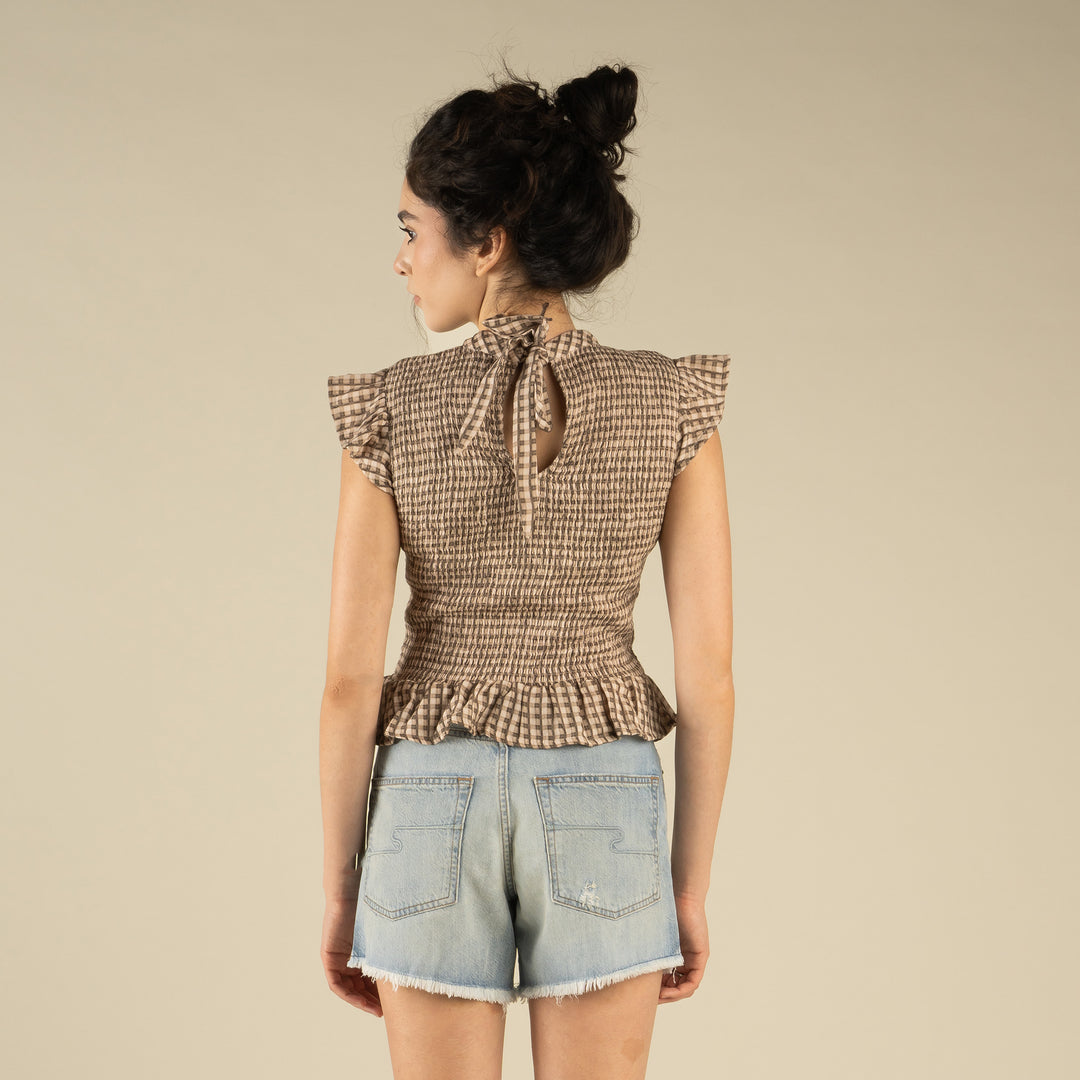 Woman wearing a brown and cream patterned top
