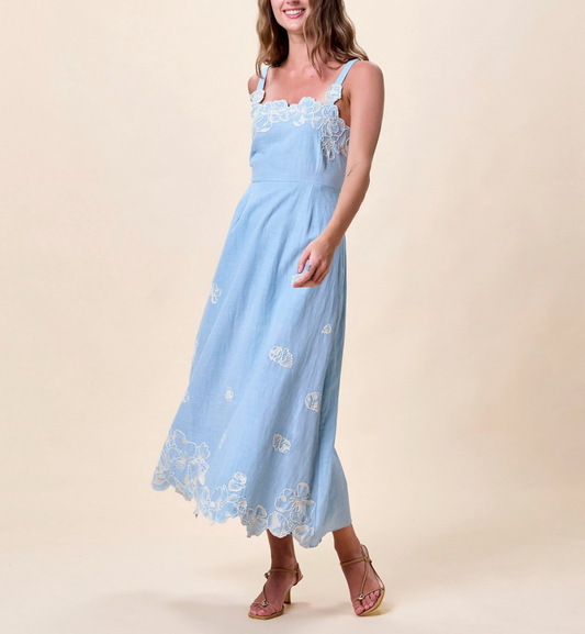 Woman wearing a light blue dress with floral embroidery