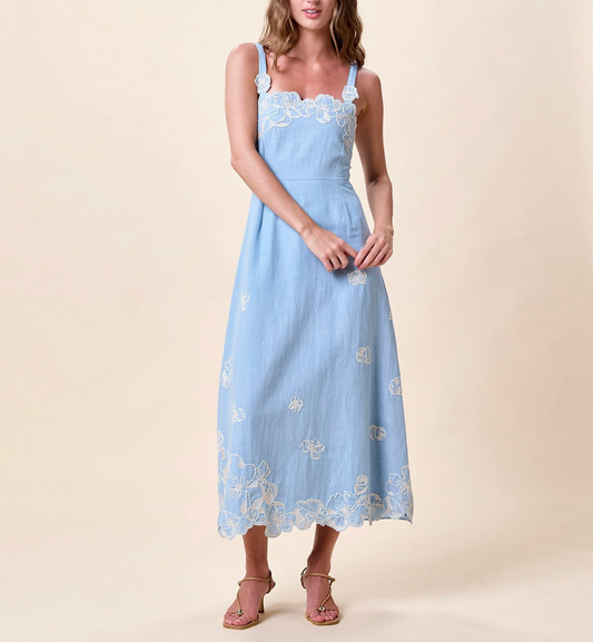 Woman wearing a light blue dress with floral embroidery