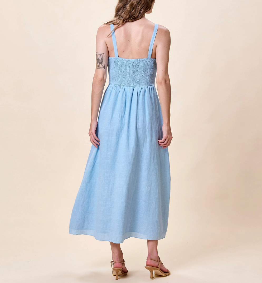 Woman wearing a light blue dress with floral embroidery