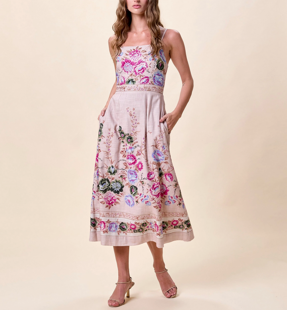 Woman wears a floral-print organic cotton midi dress in Silva color with heeled sandals, suitable for warm-weather outings.