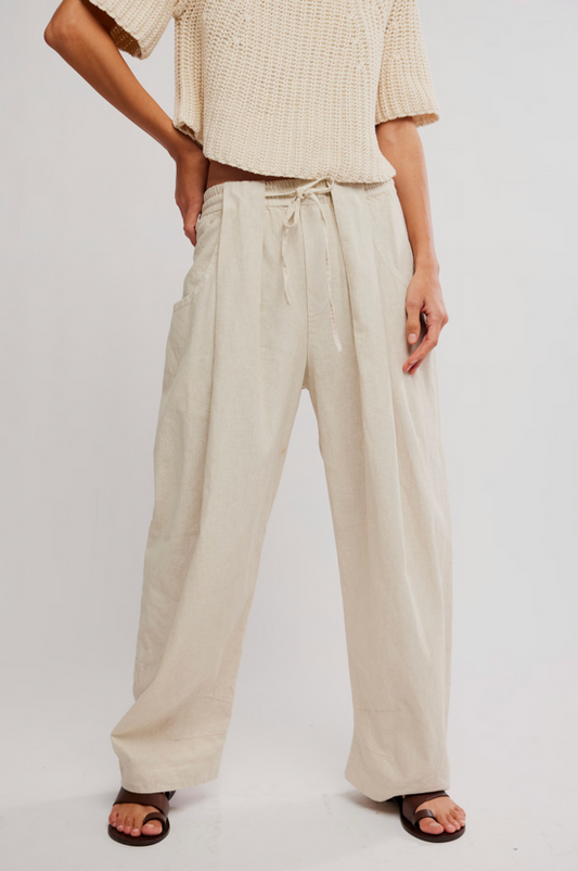 Person wears a short-sleeved knit top and light beige pull-on pants, styled with sandals for casual summer wear.