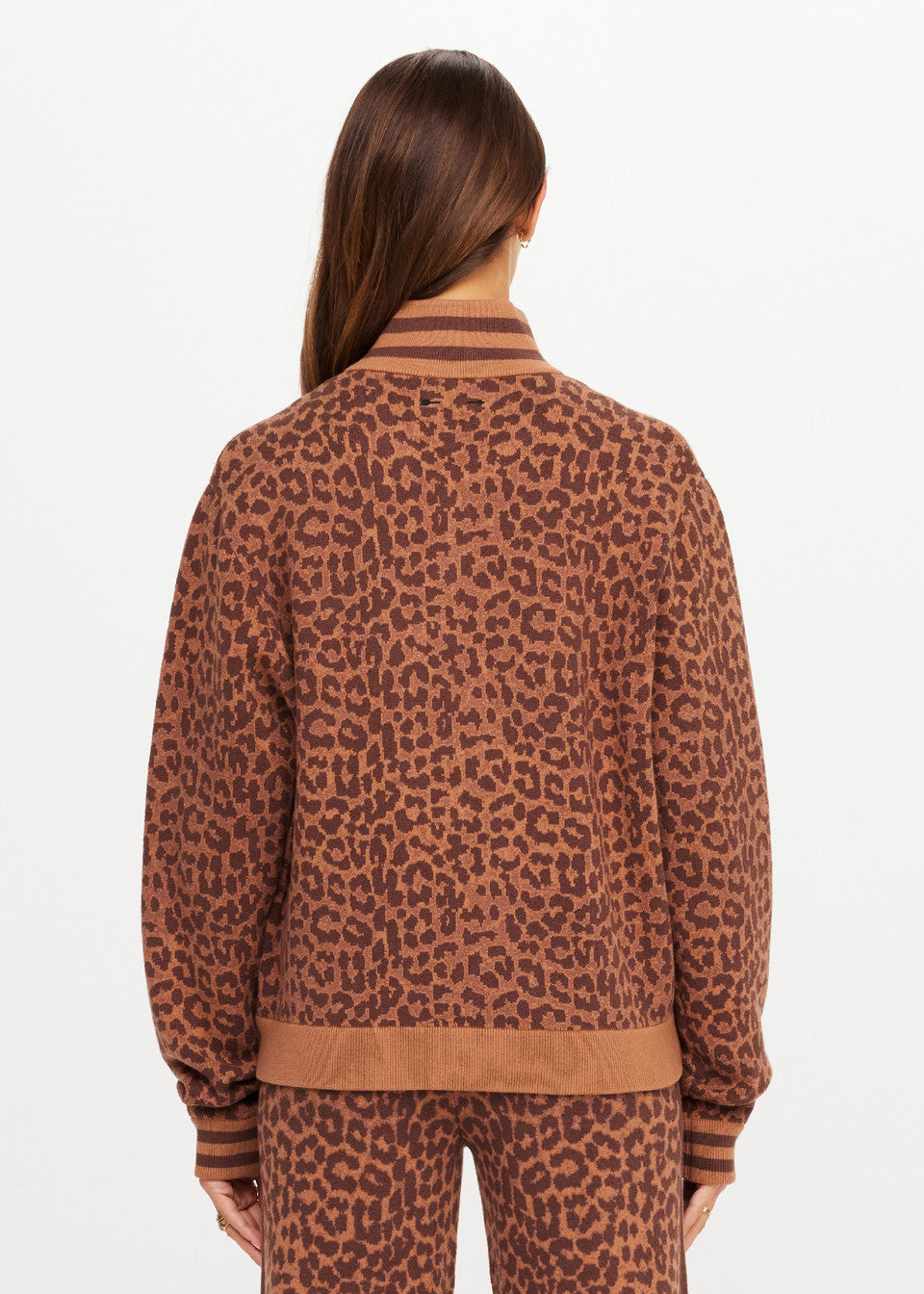Woman in leopard-print organic cotton knit jacket, back view, shown on a white background.