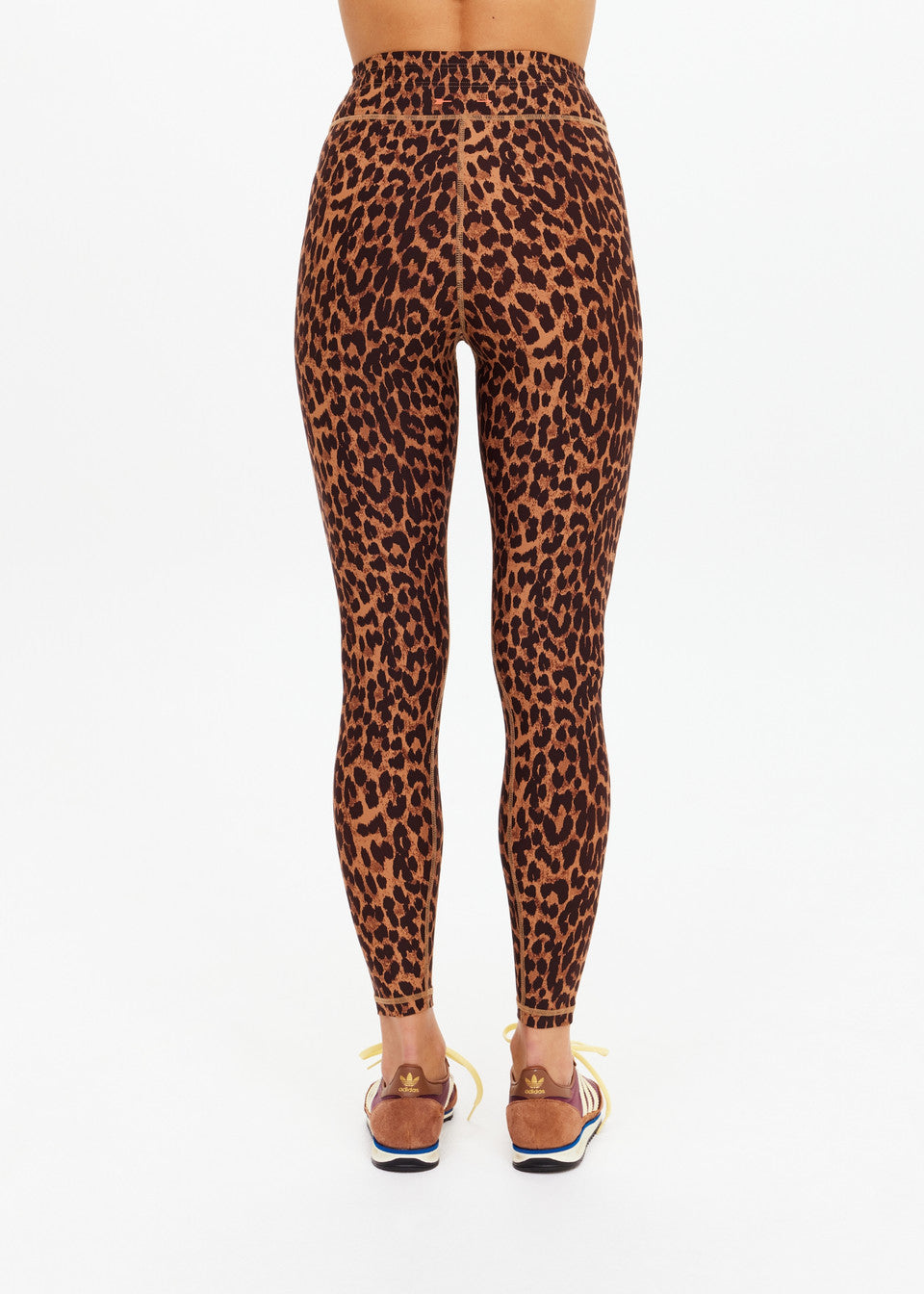 Leopard-print recycled nylon midi pants and brown sandals, shown from the back; moisture-wicking for active use.