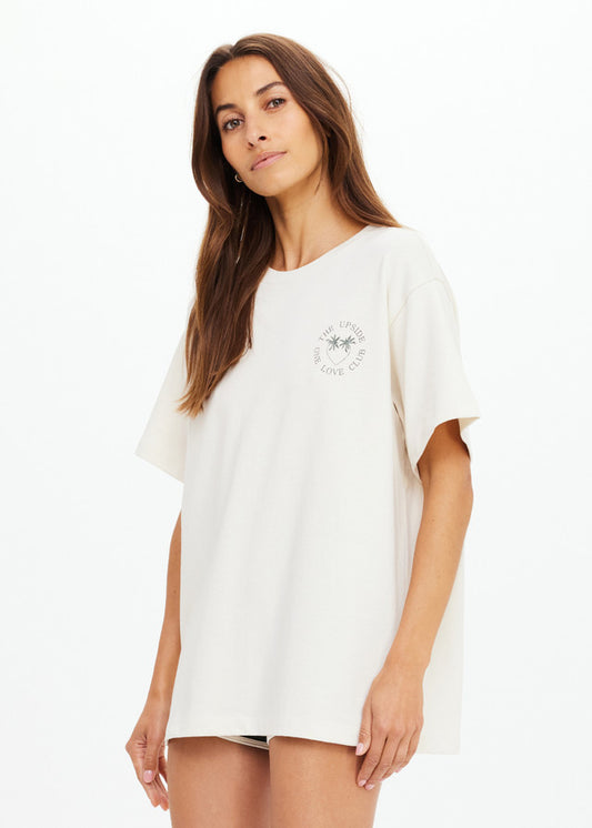 Woman in a cream oversized organic cotton tee with a palm graphic on the chest, ideal for casual wear.