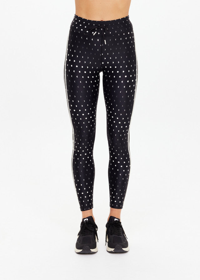 Black athletic midi pants with black sneakers, made from stretch fabric, shown on a plain white background.