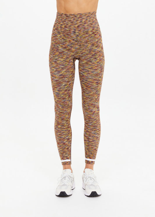 Model wears seamless, 25-inch daisy-print leggings and white sneakers, standing against a plain white background.