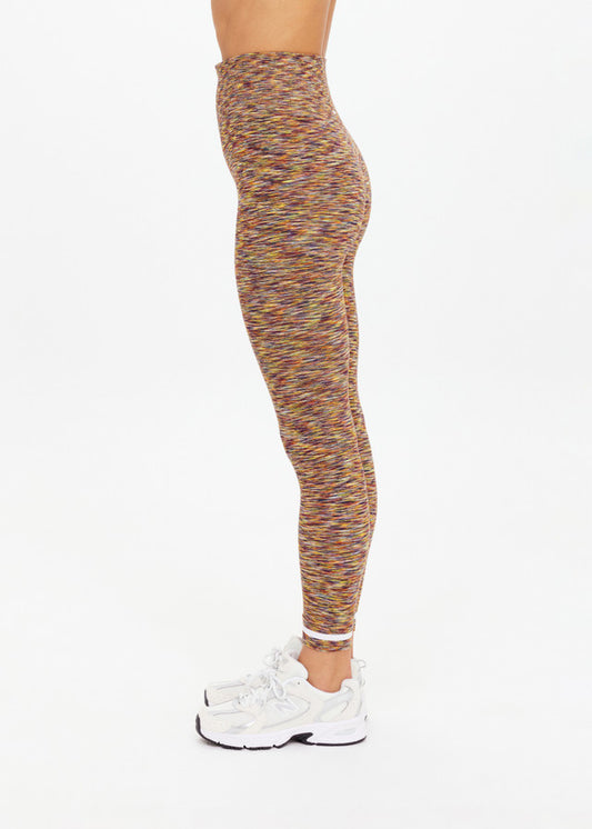 Person wearing multicolored spacedye seamless midi leggings and white sneakers, shown standing in profile.