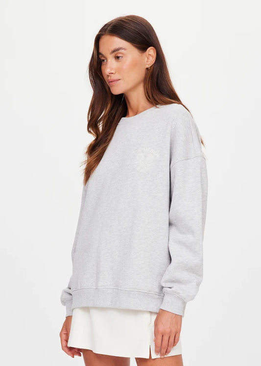 Grey marble crew sweater paired with a white skirt, displayed on a woman standing against a simple background.