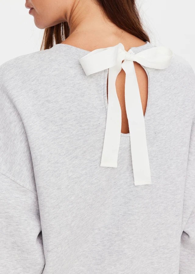 Grey marble crew sweater with keyhole back and white ribbon bow at the neckline; suitable for casual or athletic wear.