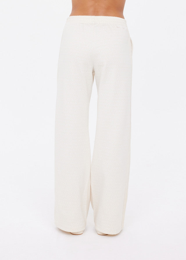Cream wide-leg pants in soft fabric, shown from the back on a white background; comfortable for casual wear.