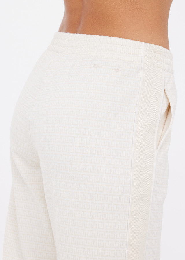 Person wearing cream wide-leg pants with side pockets and elastic waistband, suitable for casual or lounge wear.