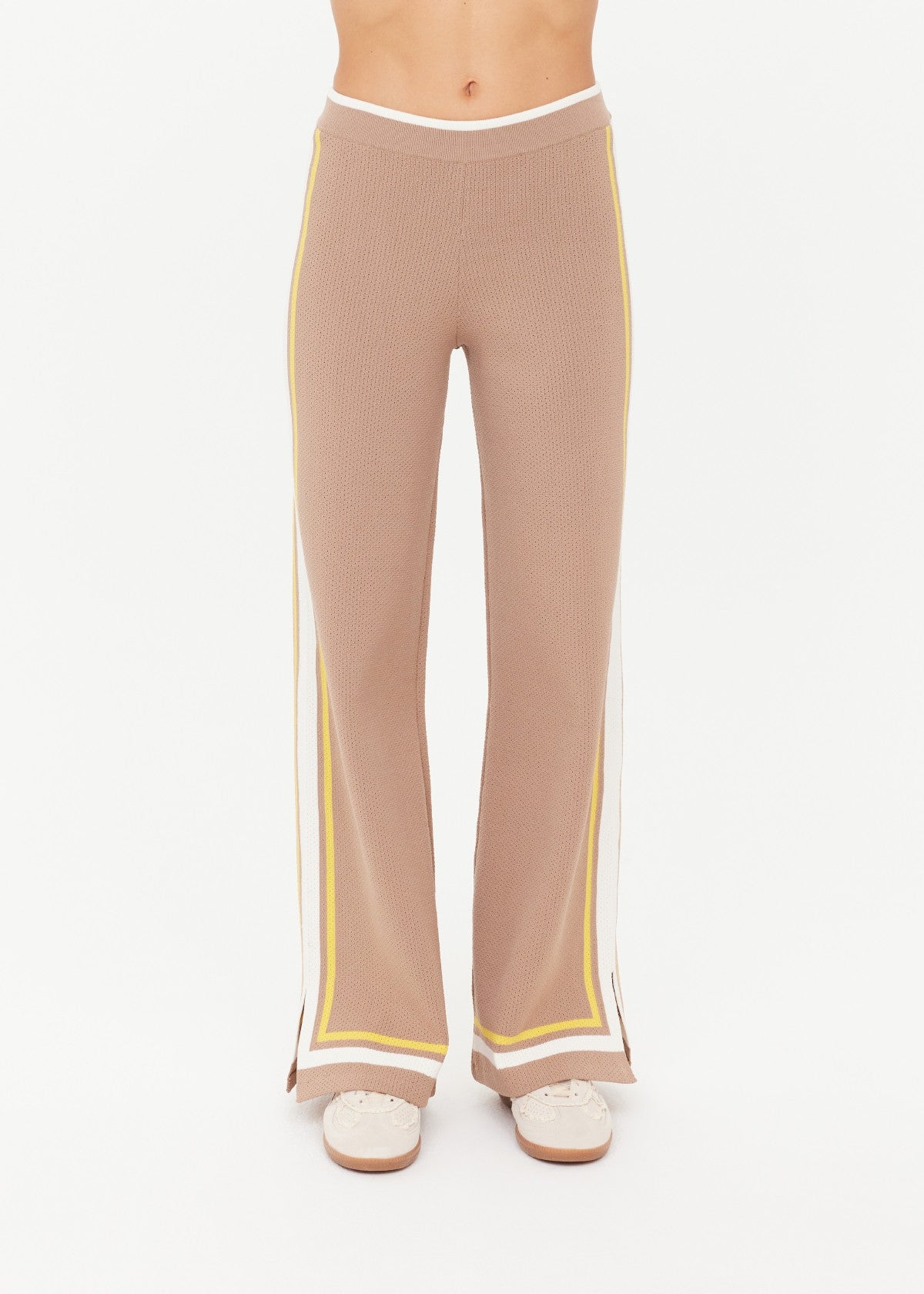 Woman wearing brown pants with yellow and white trim 