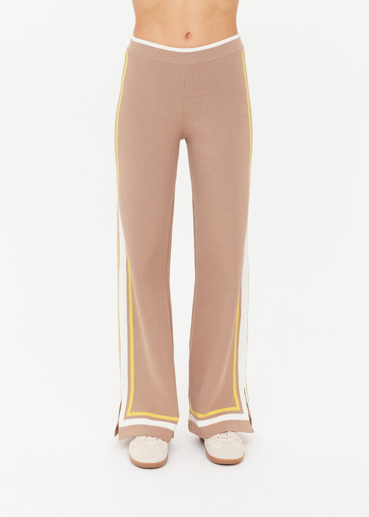 Woman wearing brown pants with yellow and white trim 