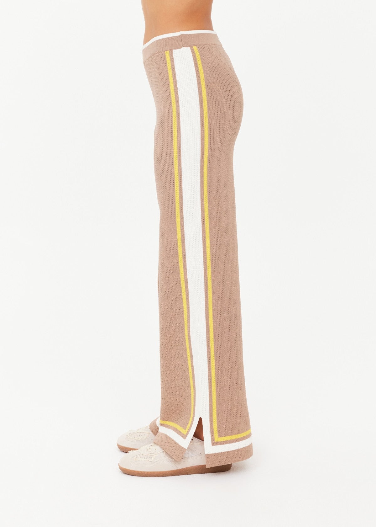 Woman wearing brown pants with yellow and white trim 
