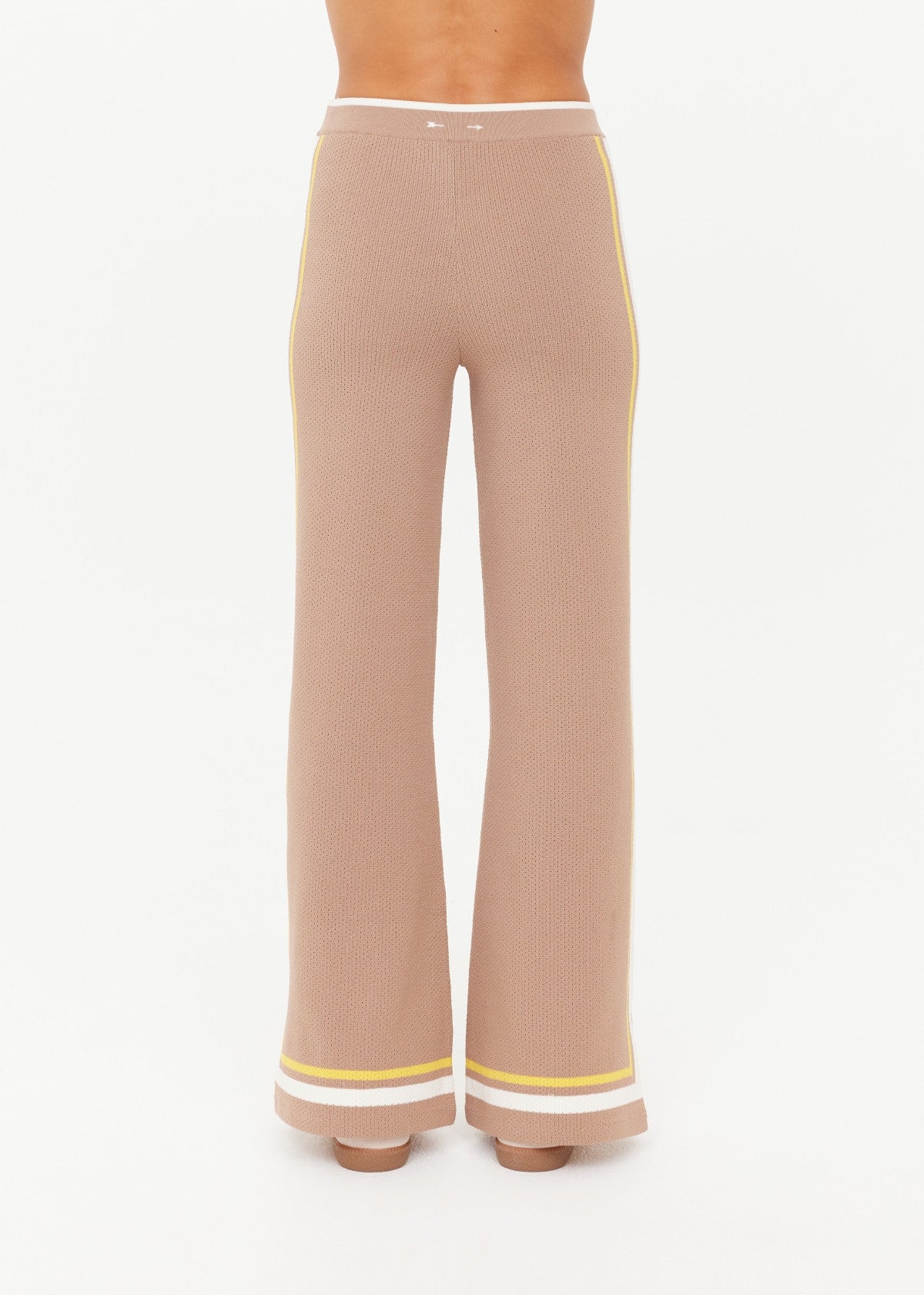 Woman wearing brown pants with yellow and white trim 