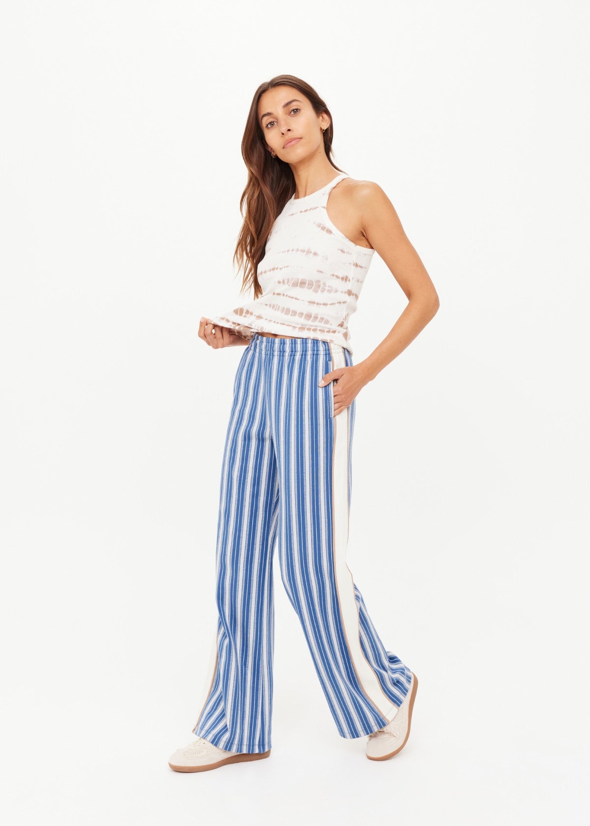 Sleeveless tie-dye top paired with wide-leg denim pants, shown against a white background.