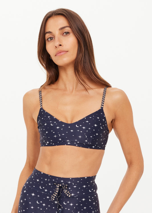 A woman modeling a navy blue two-piece lounge set with a white celestial print of stars and crescent moons