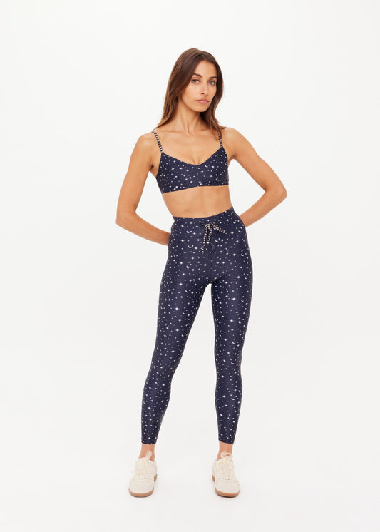 A woman modeling a navy blue two-piece lounge set with a white celestial print of stars and crescent moons