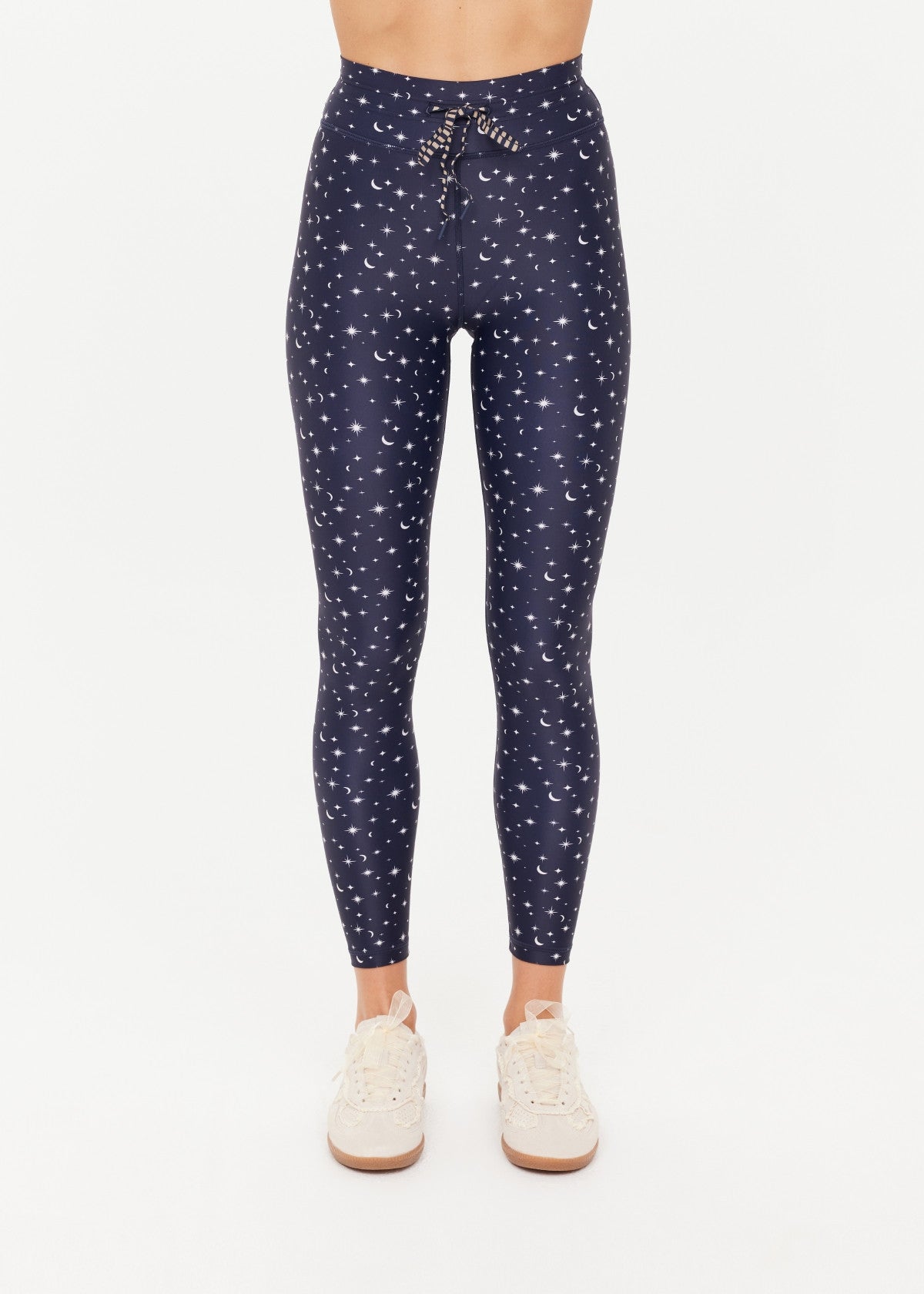 A woman wearing navy leggings with a white star and moon print
