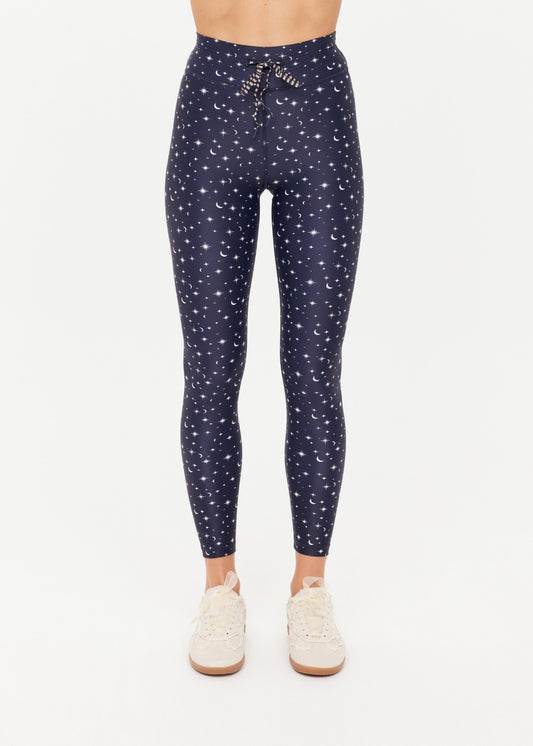 A woman wearing navy leggings with a white star and moon print