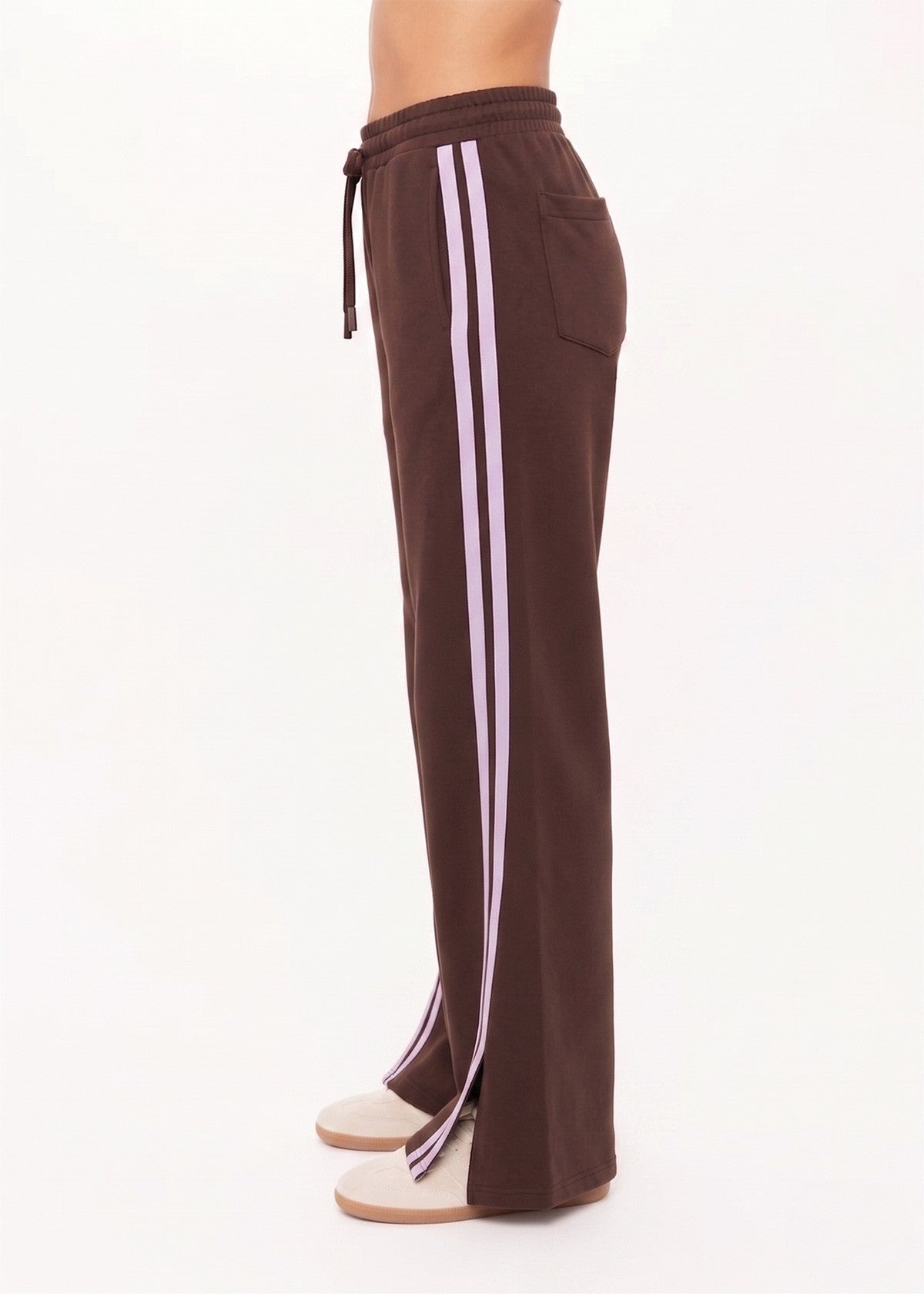 Side view of cocoa athletic pants with pink side stripes and ankle slits, shown against a white background.