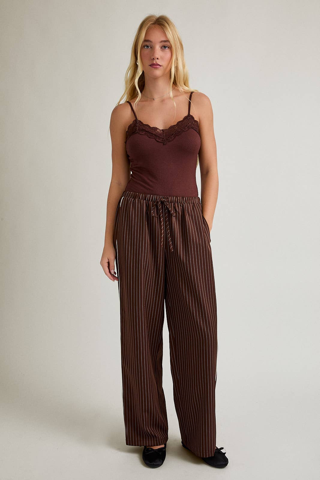 Woman wears brown bodysuit, likely knit material