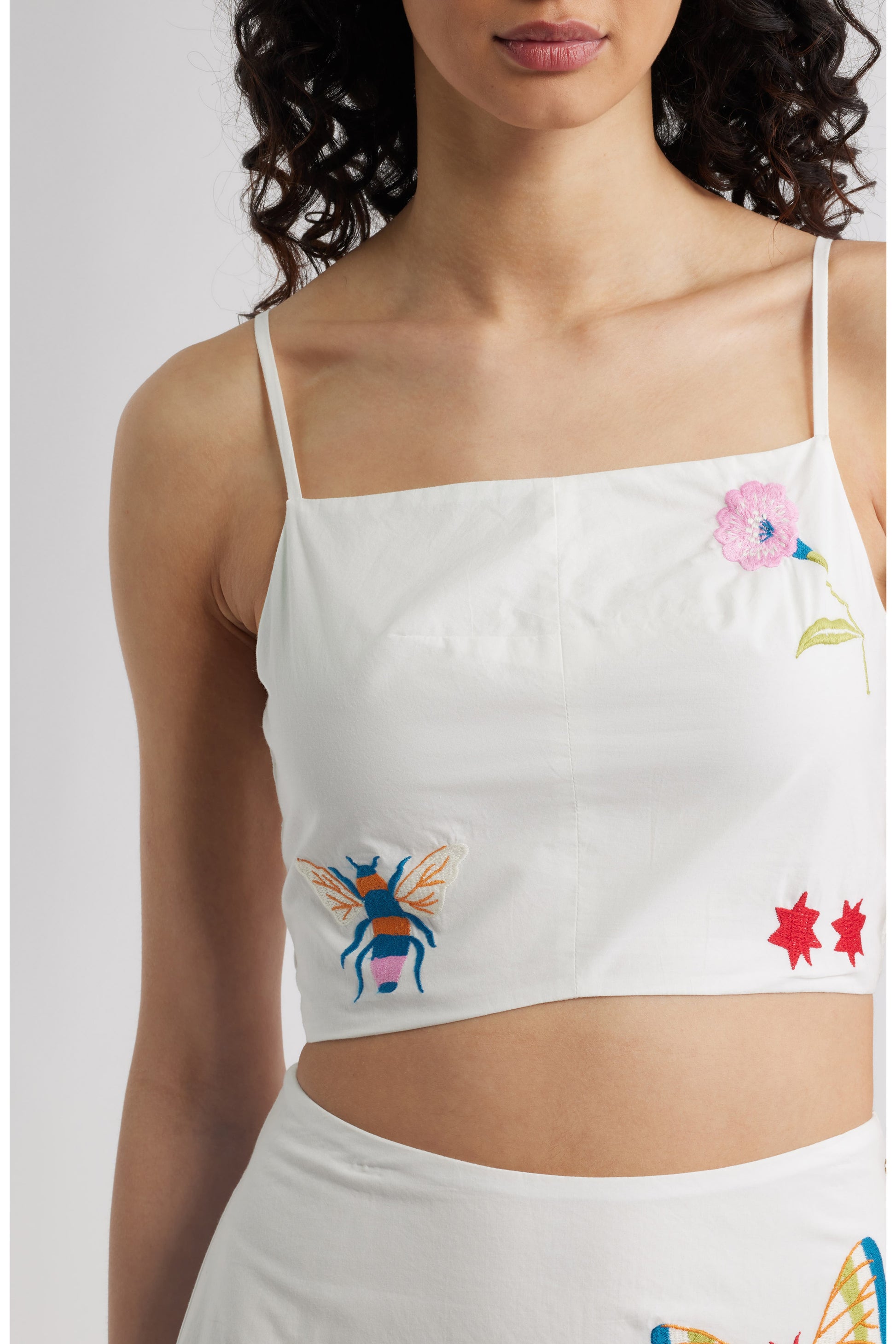 Woman in a white top with colorful designs 