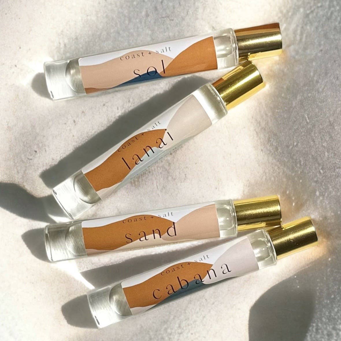 Sand perfume roller with gold cap, designed for easy application; ideal for everyday use and sunlit occasions.