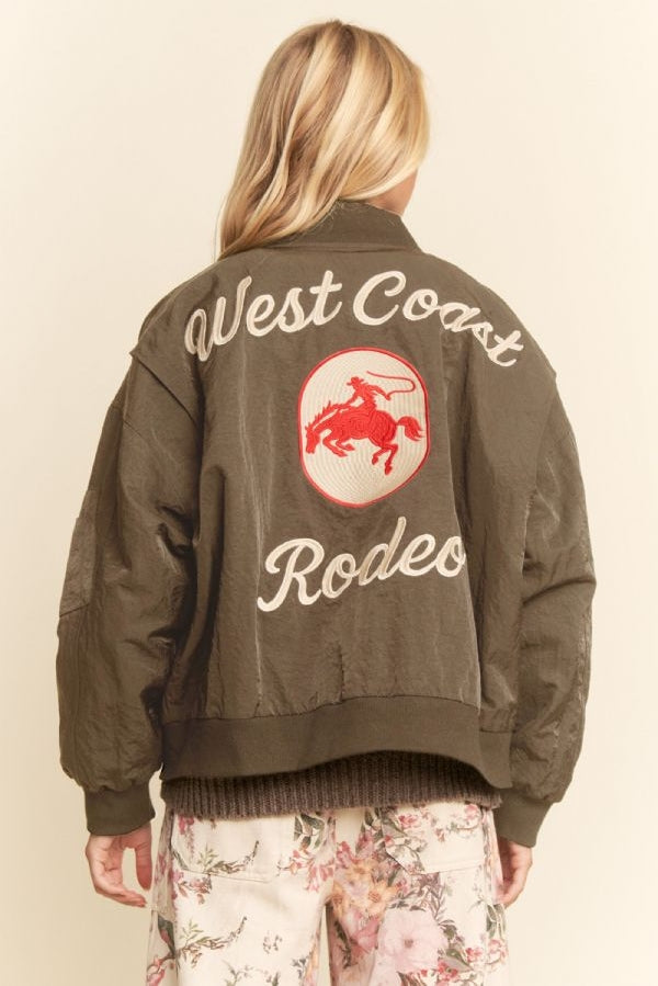 Green embroidered bomber jacket with red rodeo graphic on the back, suitable for casual wear.