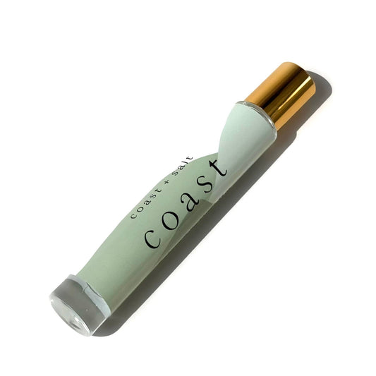 Perfume roller with a gold cap; features a fresh coastal sandalwood scent for personal fragrance use.