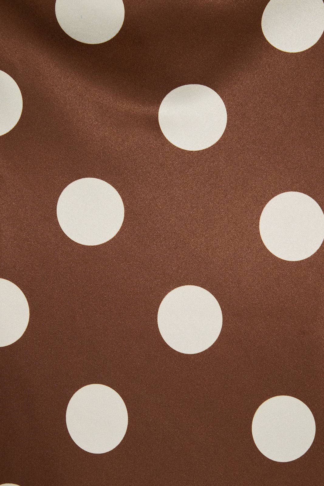 Brown skirt with large white polka dots, made of soft fabric, suitable for women’s casual or dressy wear.