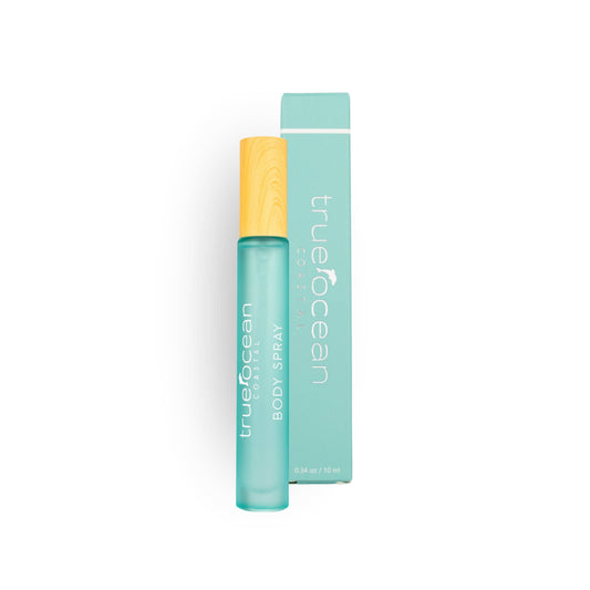 Turquoise body spray with yellow cap, for fresh scent, next to its box on a plain white background.