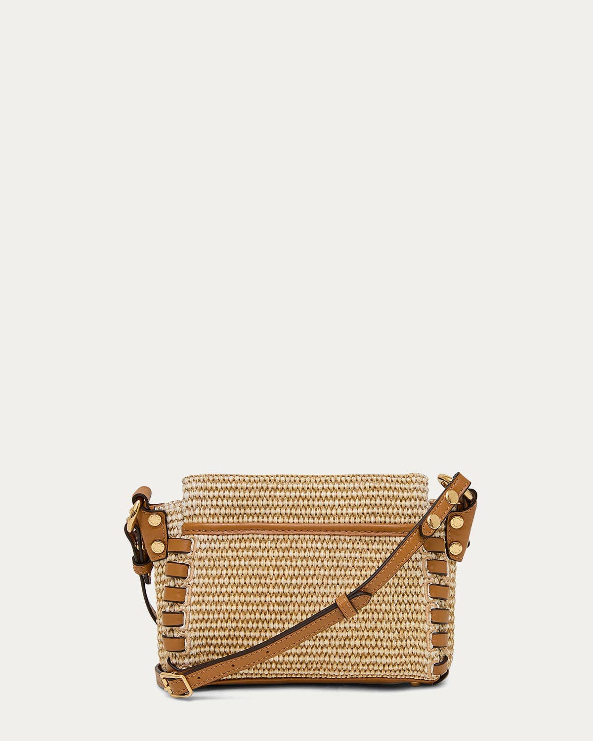 Woven straw crossbody bag with brown leather trim, gold studs, and an adjustable strap for everyday use.