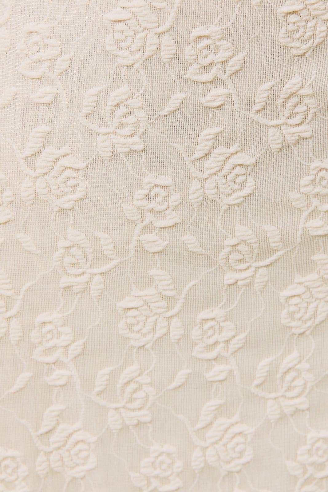 Cream mini dress with embossed floral rose pattern, suitable for various occasions.