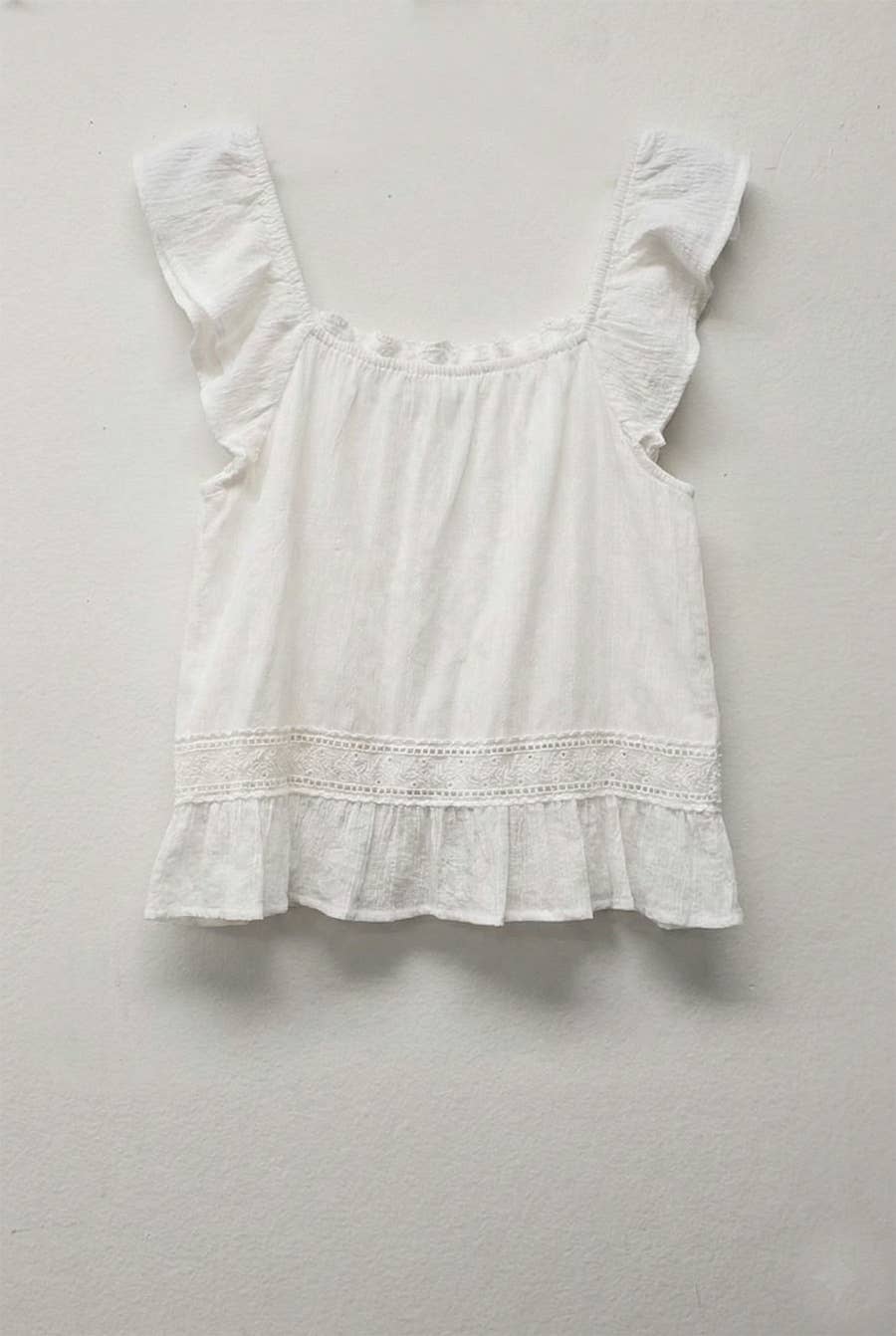 Natural-colored ruffle sleeve top with crochet lace details on straps and hem, displayed on neutral background.