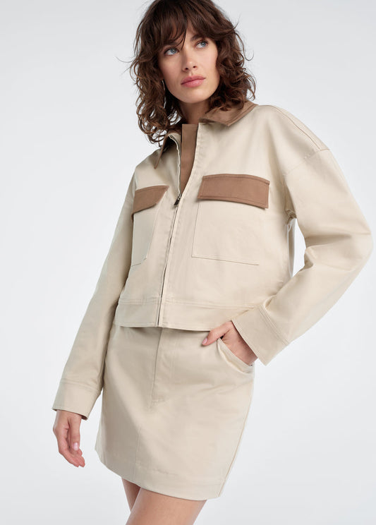 Woman wearing a beige jacket with khaki accents