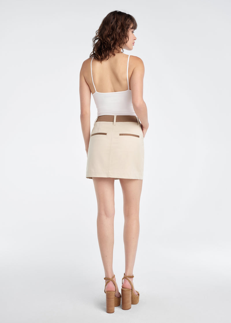 Woman wearing a beige skirt with brown accents 