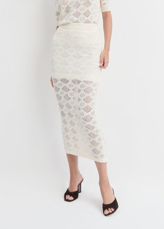 Ivory skirt paired with brown heeled sandals, shown on a person against a plain white background.