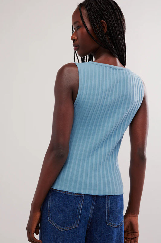 Woman wearing a light blue ribbed tank top with button details